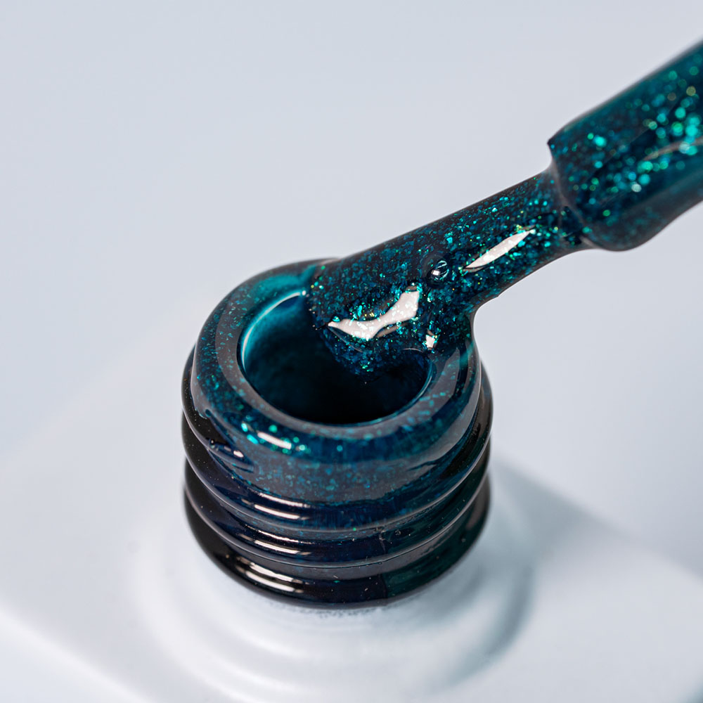 Lakier hybrydowy No. 089 - w odcieniu morskiego brokatu - pędzelek zanurzony w lakierze