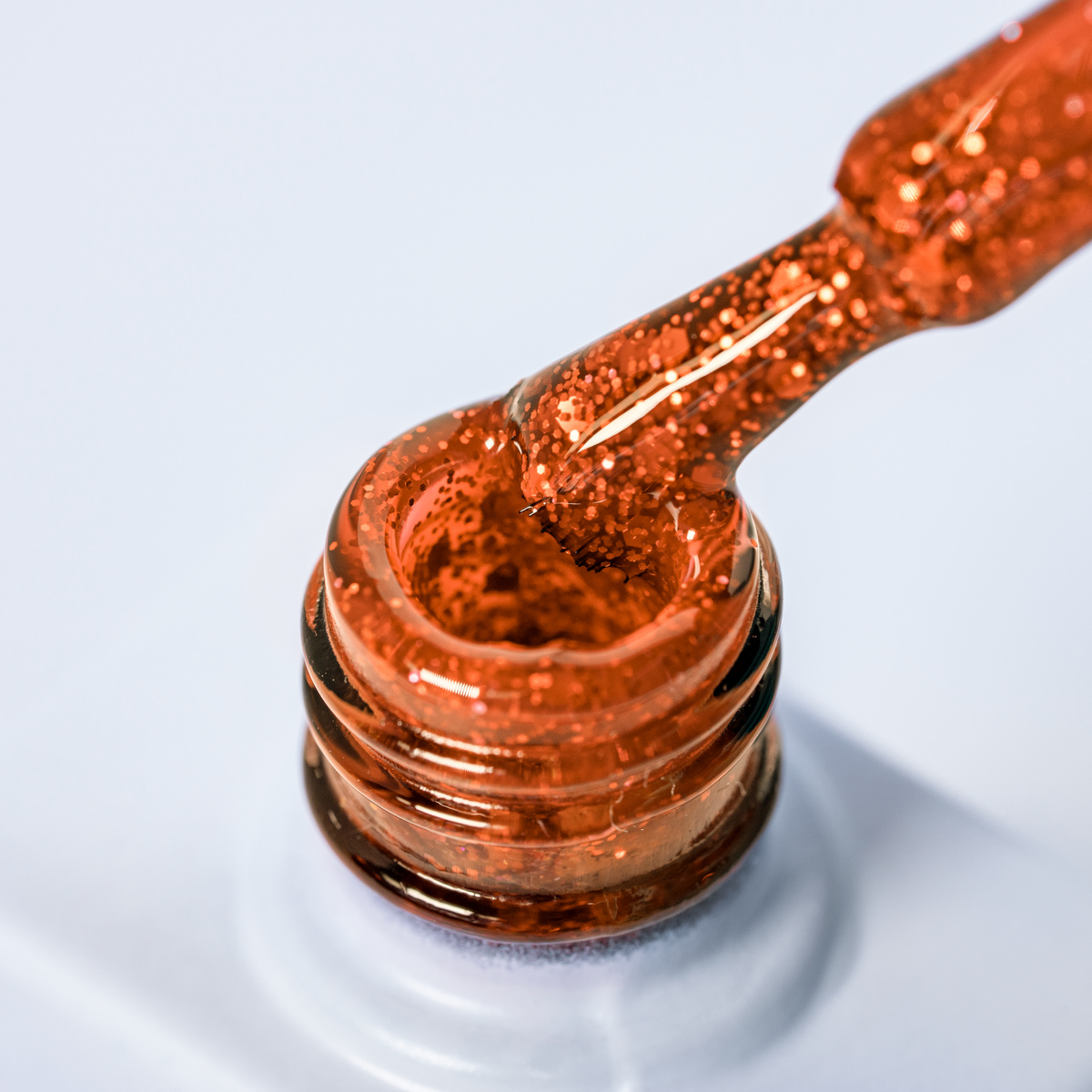 Lakier hybrydowy No. 144 - miedziany brokatowy - pędzelek zanurzony w lakierze