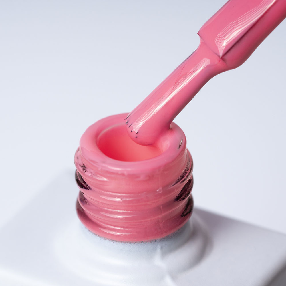 Lakier hybrydowy No 003 – Jasnoróżowy neon na pędzelku Lakier hybrydowy No. 003 - w odcieniu jasnoróżowym neonowym - pędzelek zanurzony w lakierze