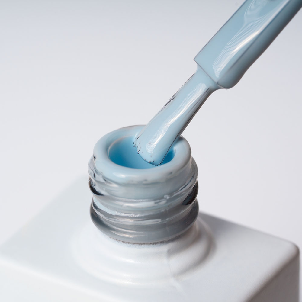 Lakier hybrydowy No 010 – Jasnobłękitny na pędzelku Lakier hybrydowy No. 010 - w odcieniu jasnobłękitnym - pędzelek zanurzony w lakierze