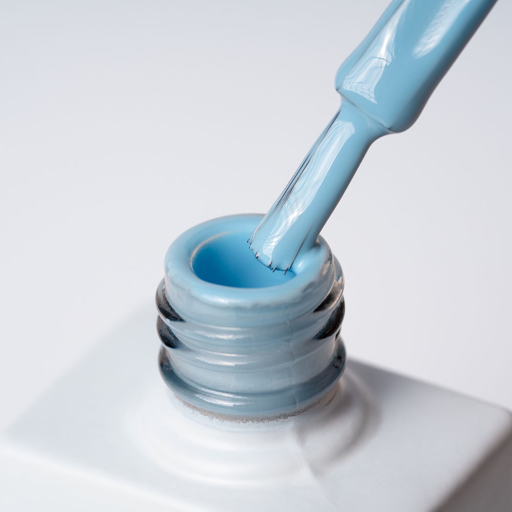 Lakier hybrydowy No 011 – Błękitny na pędzelku Lakier hybrydowy No. 011 - w odcieniu błękitnym - pędzelek zanurzony w lakierze
