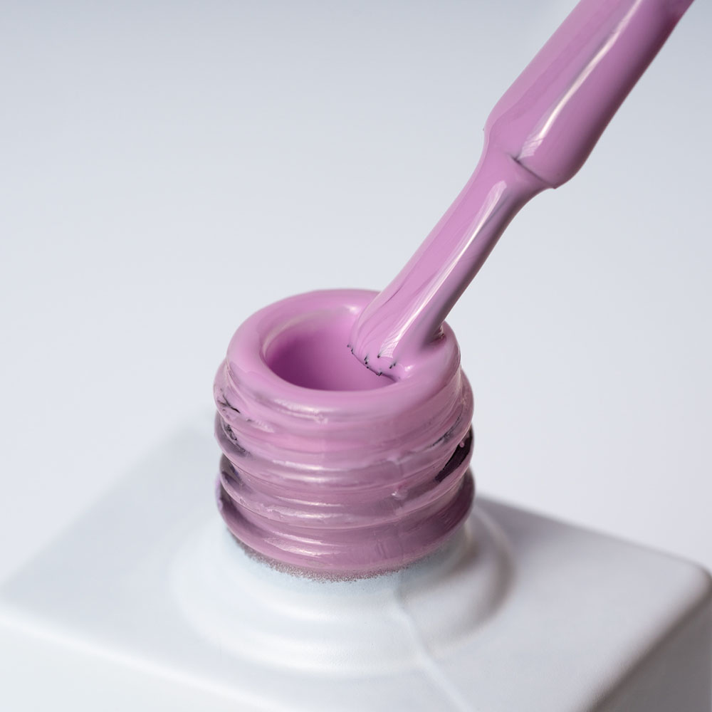 Lakier hybrydowy No 012 – Pastelowy Fiolet na pędzelku Lakier hybrydowy No. 012 - w odcieniu pastelowy fiolet - pędzelek zanurzony w lakierze