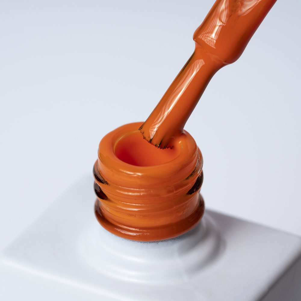 Lakier hybrydowy No 013 – Pomarańczowy na pędzelku Lakier hybrydowy No. 013 - w odcieniu pomarańczowym - pędzelek zanurzony w lakierze