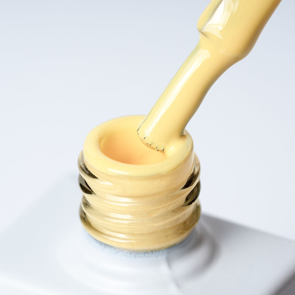 Lakier hybrydowy No 014 – Słonecznikowy na pędzelku Lakier hybrydowy No. 014 - w odcieniu żółty słonecznikowy - pędzelek zanurzony w lakierze