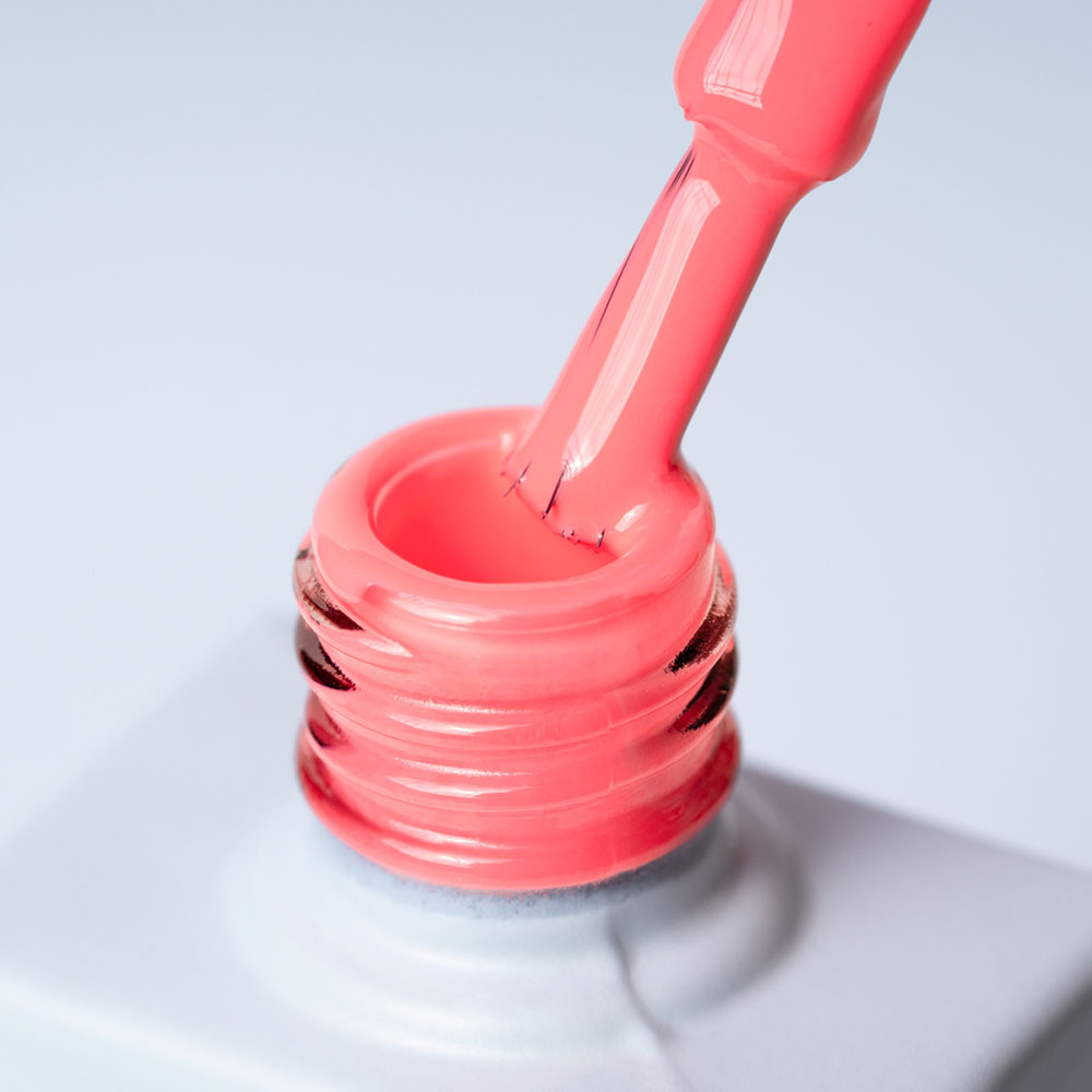 Lakier hybrydowy No 022 – Różowy Neon na pędzelku Lakier hybrydowy No. 022 - w odcieniu różowego neonu - pędzelek zanurzony w lakierze