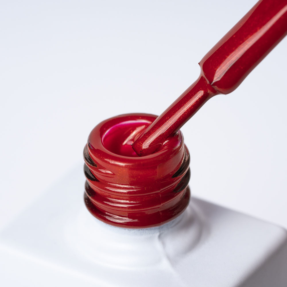 Lakier hybrydowy No. 099 - w odcieniu czerwony metaliczny - pędzelek zanurzony w lakierze