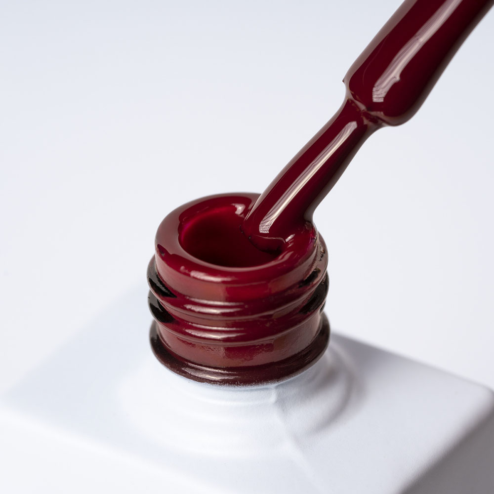 Lakier hybrydowy No. 102 - w odcieniu ciemny czerwony - pędzelek zanurzony w lakierze