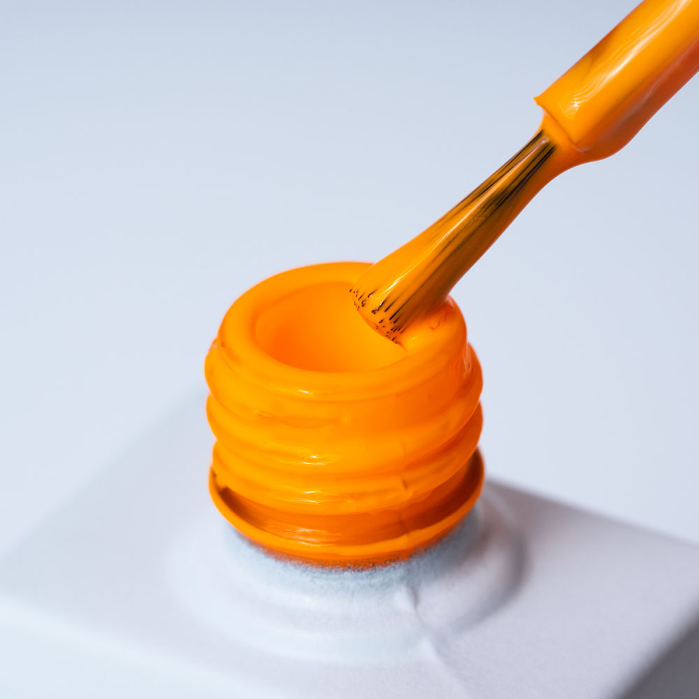 Lakier hybrydowy No. 134 - w odcieniu mandarynkowym - pędzelek zanurzony w lakierze