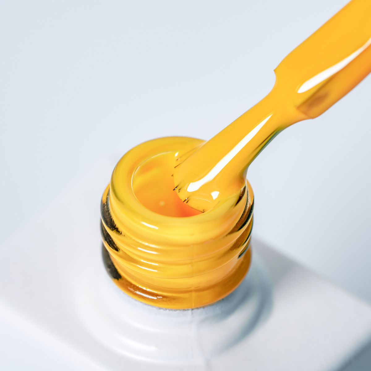 Lakier hybrydowy No. 143 - w odcieniu ciepłego żółtego - pędzelek zanurzony w lakierze