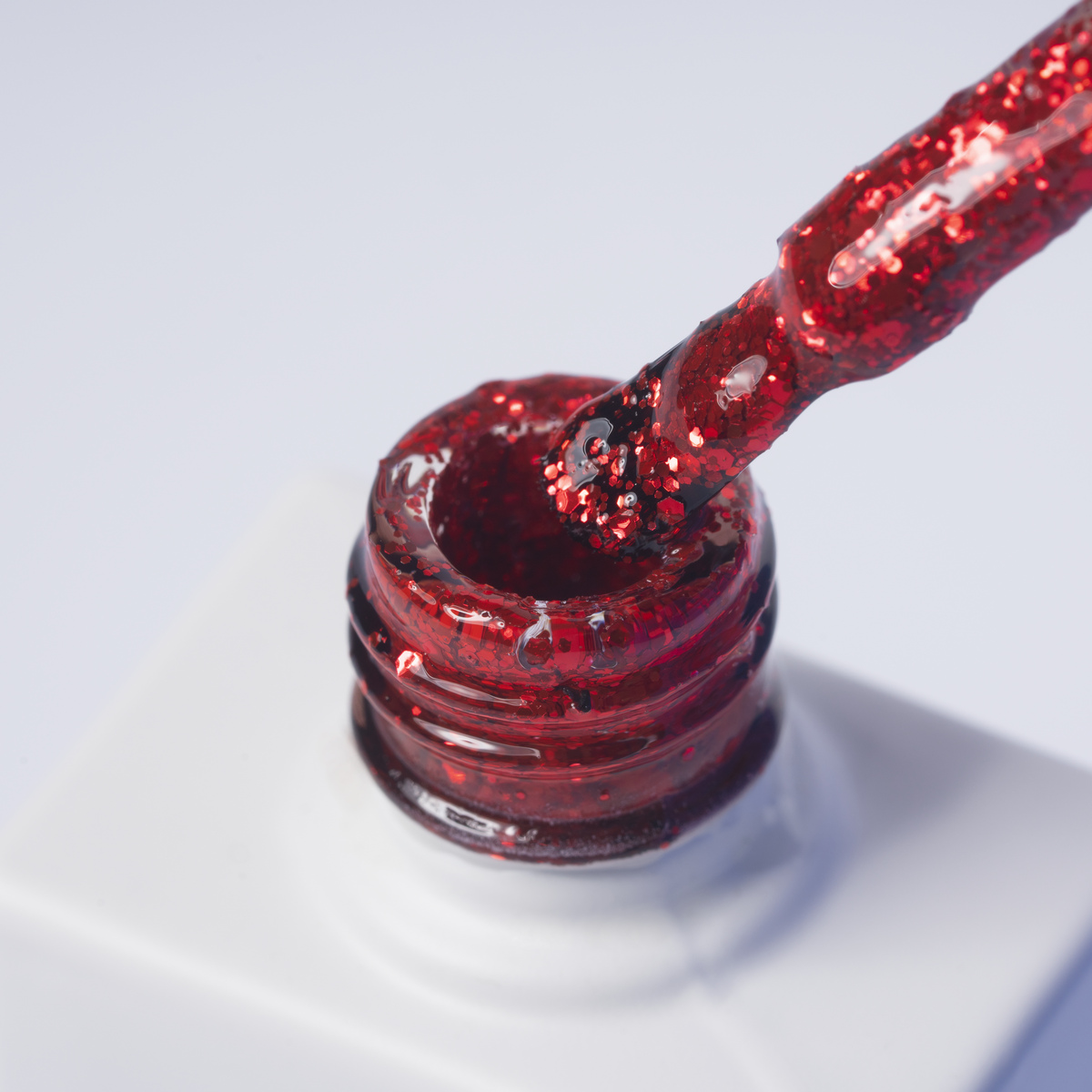 Lakier hybrydowy No 157 - w odcieniu czerwonym brokatowym - pędzelek zanurzony w lakierze