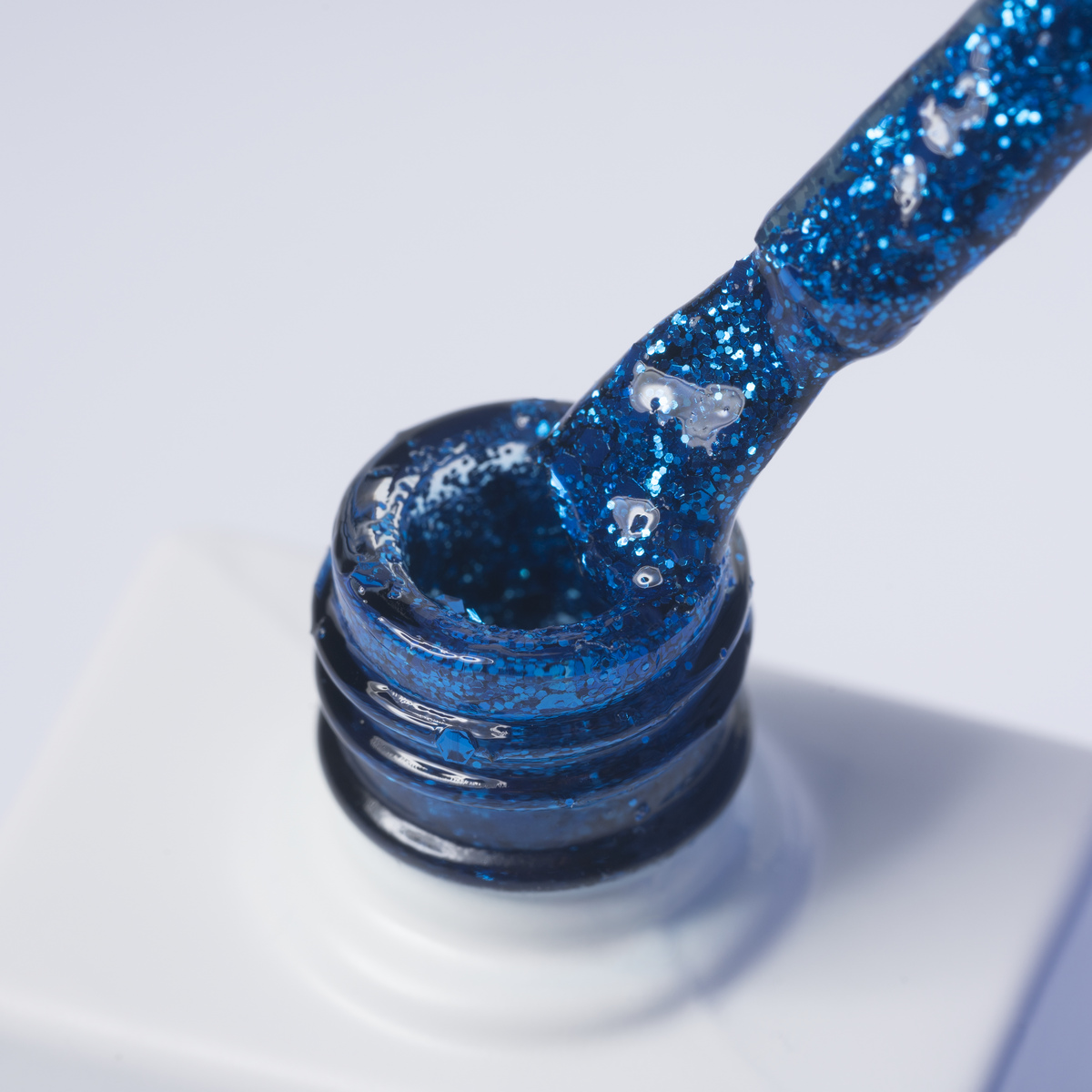 Lakier hybrydowy No.159 - niebieski z brokatem - pędzelek zanurzony w lakierze