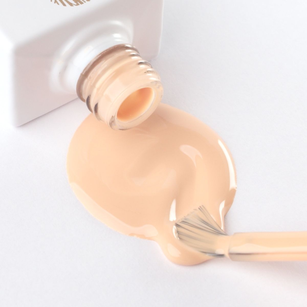 Lakier hybrydowy No. 206 - w odcieniu rozbielony mandarynkowy - pędzelek zanurzony w lakierze