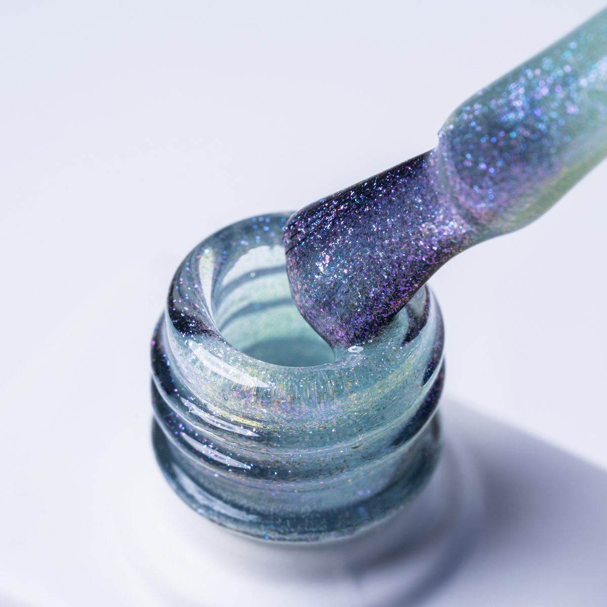 Pędzelek z lakierem UV/LED FRØSTH No 004 ‘Sparkly Fogg’ srebrno‑brokatowy odcień - pędzelek zanurzony w lakierze